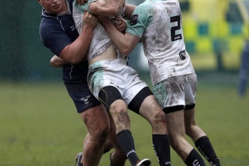 Craig Winfield of Cambridge is tackled by Sven Kerneis (L) during the RCMA Varsity Rugby League game between Cambridge University and Oxford University at the HAC Ground, Moorgate, London on Fri Mar 9, 2018